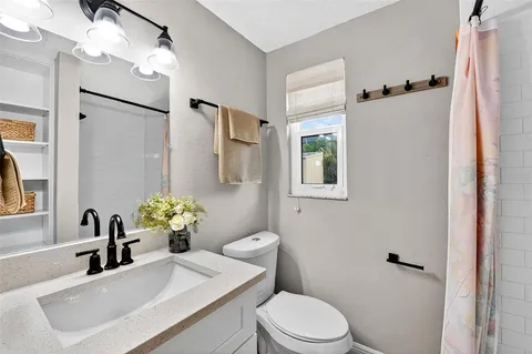 a bathroom with a sink toilet and shower