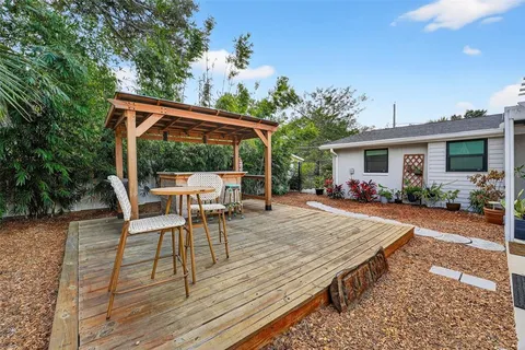 a view of a patio with table and chairs potted plants with wooden floor and fence