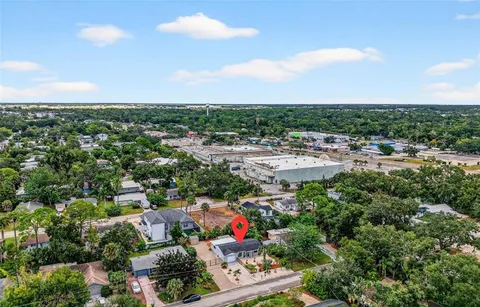 an aerial view of a city with lots of residential buildings ocean and mountain view in back