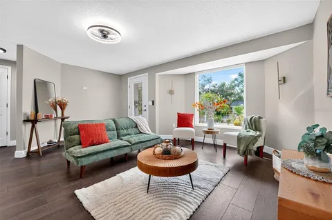a living room with furniture a rug and a large window