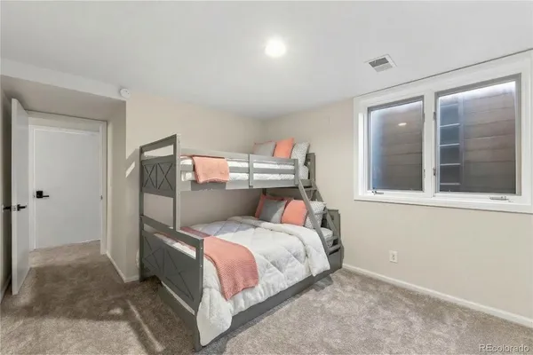 a bed sitting in a bedroom next to a window and a bathroom