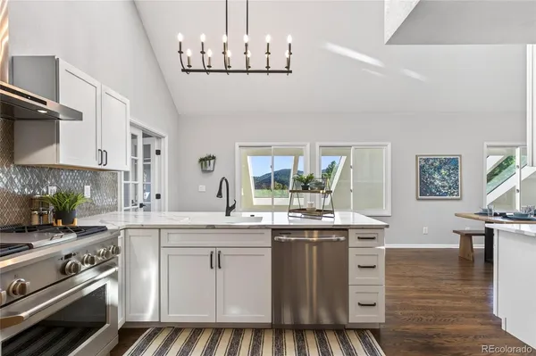 a kitchen with kitchen island granite countertop a sink cabinets and wooden floor