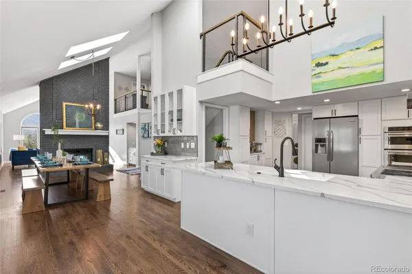 a large white kitchen with stainless steel appliances granite countertop a stove and cabinets