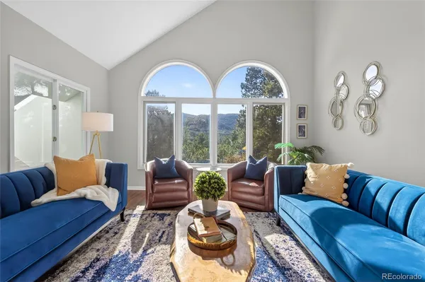 a living room with furniture fireplace and a large window
