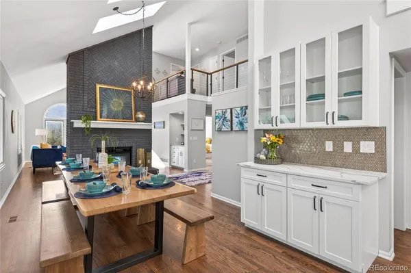 a open kitchen with granite countertop a stove and white cabinets with wooden floor