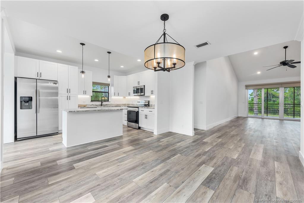 13468 Northwest Harbour Ridge Boulevard, Unit 2A Palm City, FL 34990 - Photo 11 of 38 a view of a kitchen with stainless steel appliances granite countertop a refrigerator a stove and a wooden floors