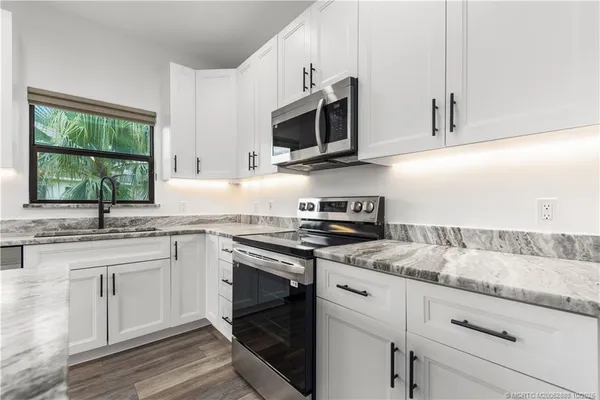 a kitchen with stainless steel appliances granite countertop a sink and a stove