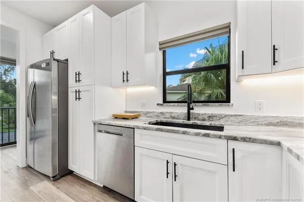 a kitchen with stainless steel appliances granite countertop a refrigerator and a sink