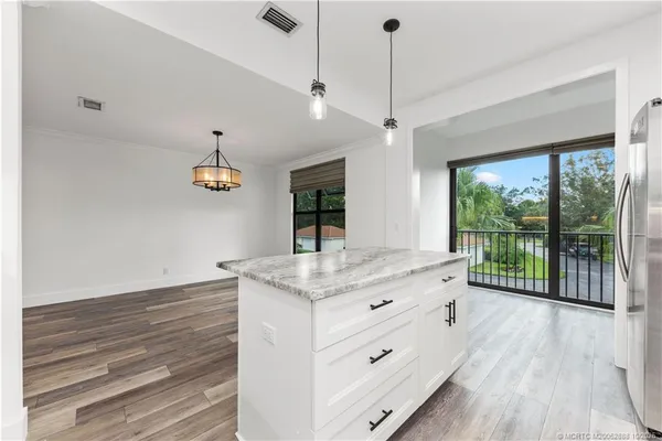 a bathroom with a granite countertop sink a large mirror and a large window