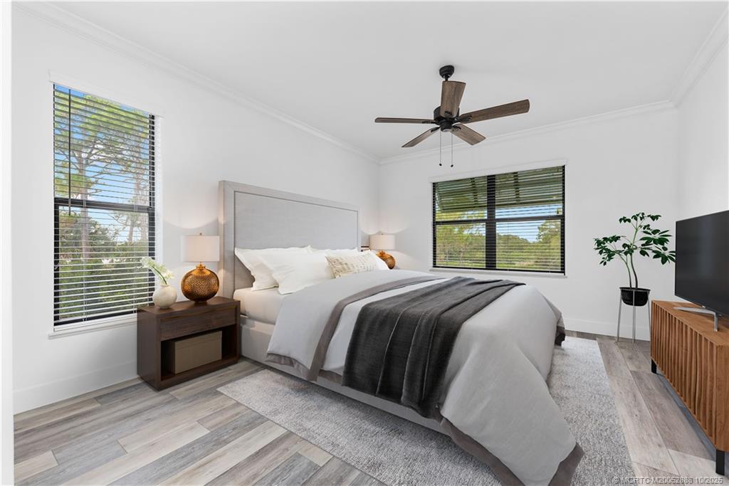 13468 Northwest Harbour Ridge Boulevard, Unit 2A Palm City, FL 34990 - Photo 17 of 38 a bedroom with a bed and wooden floor