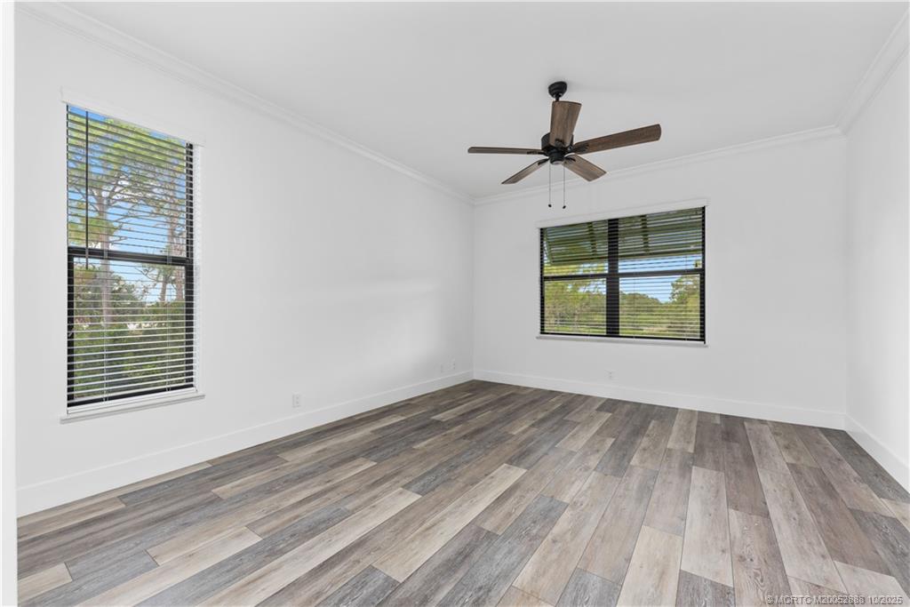 13468 Northwest Harbour Ridge Boulevard, Unit 2A Palm City, FL 34990 - Photo 18 of 38 a view of an empty room with window and wooden floor
