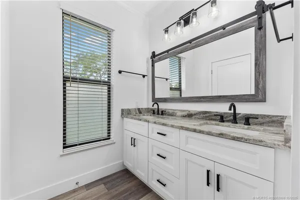 a bathroom with a granite countertop sink vanity and mirror