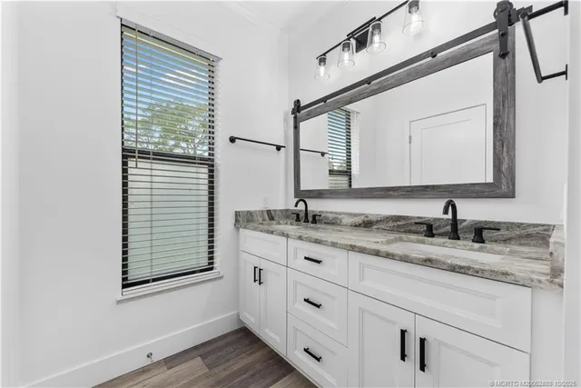 a bathroom with a granite countertop sink vanity and mirror