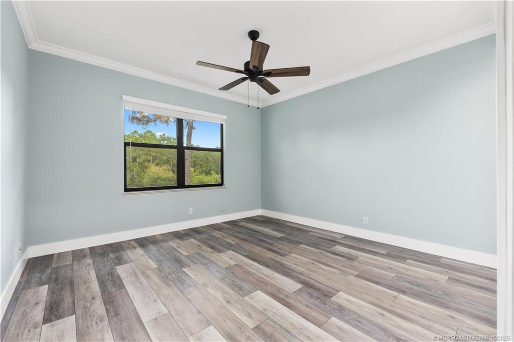 13468 Northwest Harbour Ridge Boulevard, Unit 2A Palm City, FL 34990 - Photo 23 of 38 a view of an empty room with window and ceiling fan