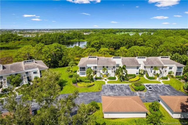 an aerial view of residential houses with outdoor space and trees