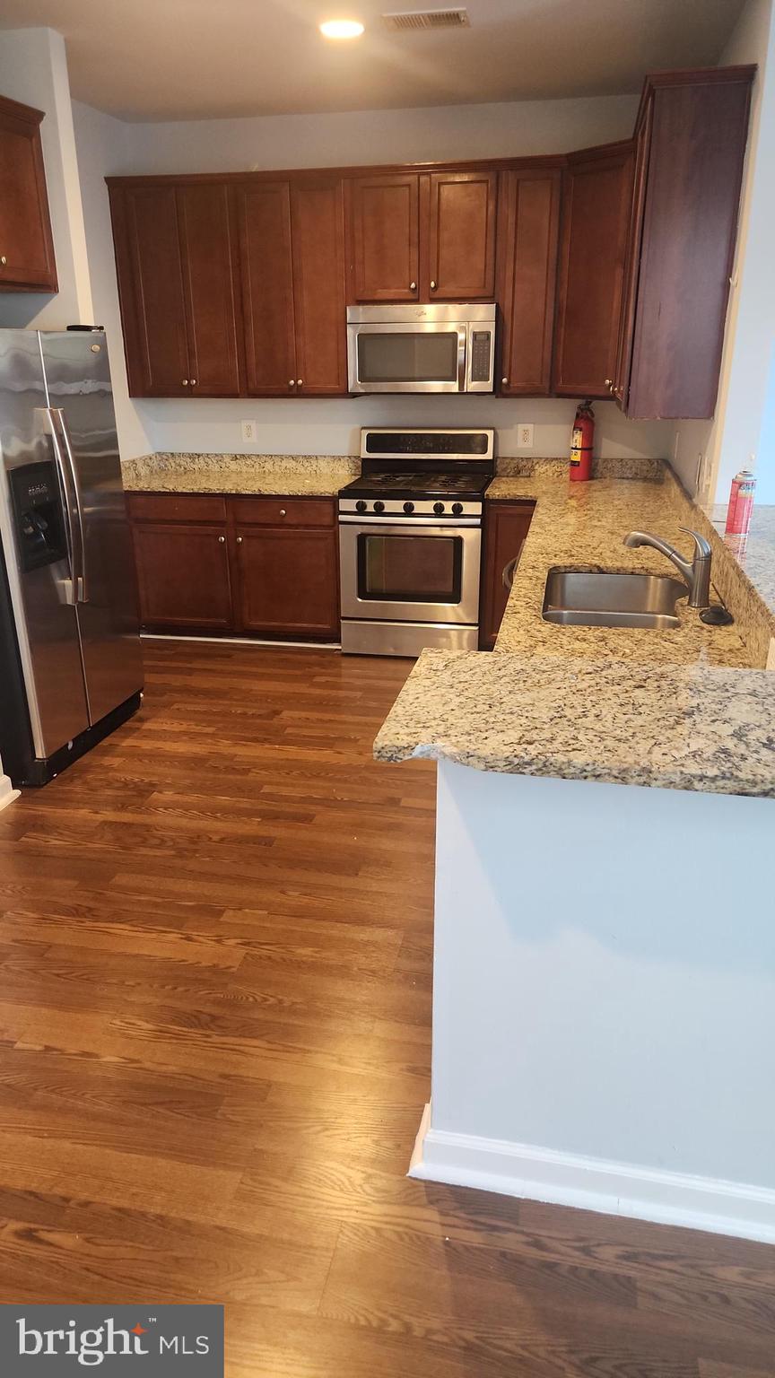 11612 Leesborough Circle Silver Spring, MD 20902 - Photo 11 of 29 a kitchen with a sink a stove and cabinets