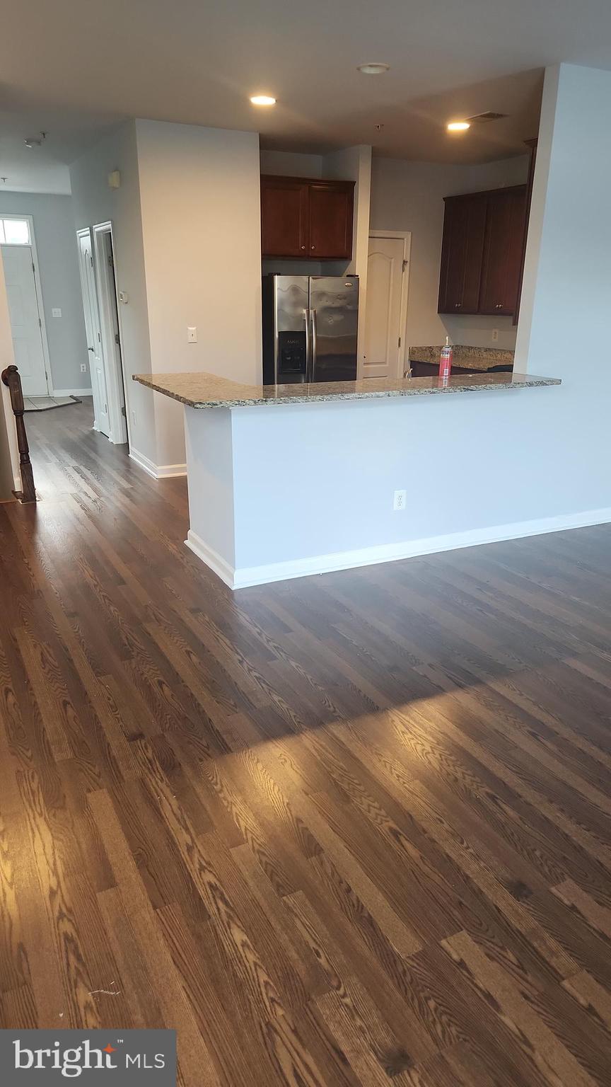 11612 Leesborough Circle Silver Spring, MD 20902 - Photo 12 of 29 a view of an empty room with wooden floor and a kitchen