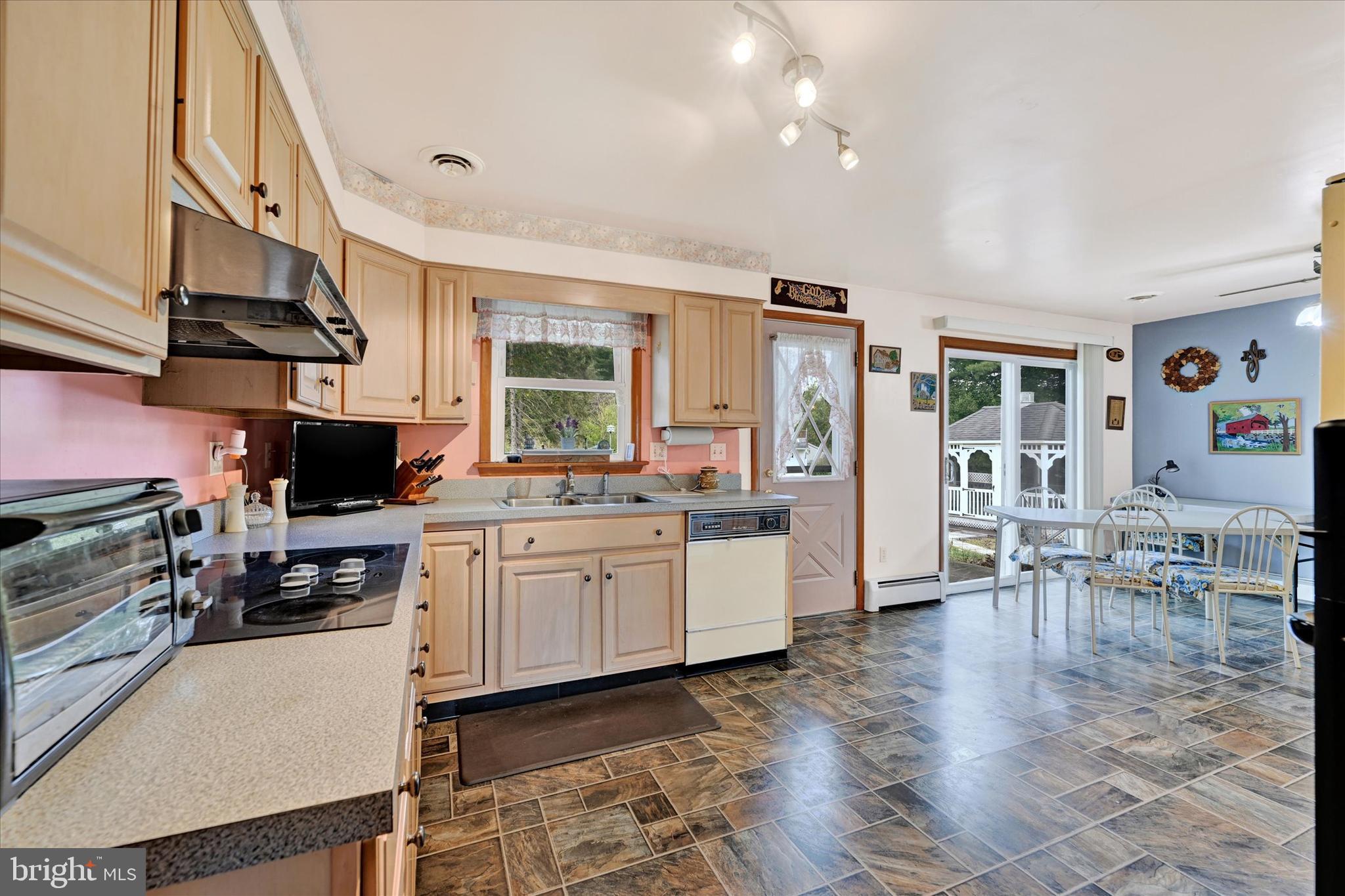 700 Remington Road Fallston, MD 21047 - Photo 10 of 42 a kitchen with stainless steel appliances granite countertop a stove top oven a sink a dining table and chairs with wooden floor