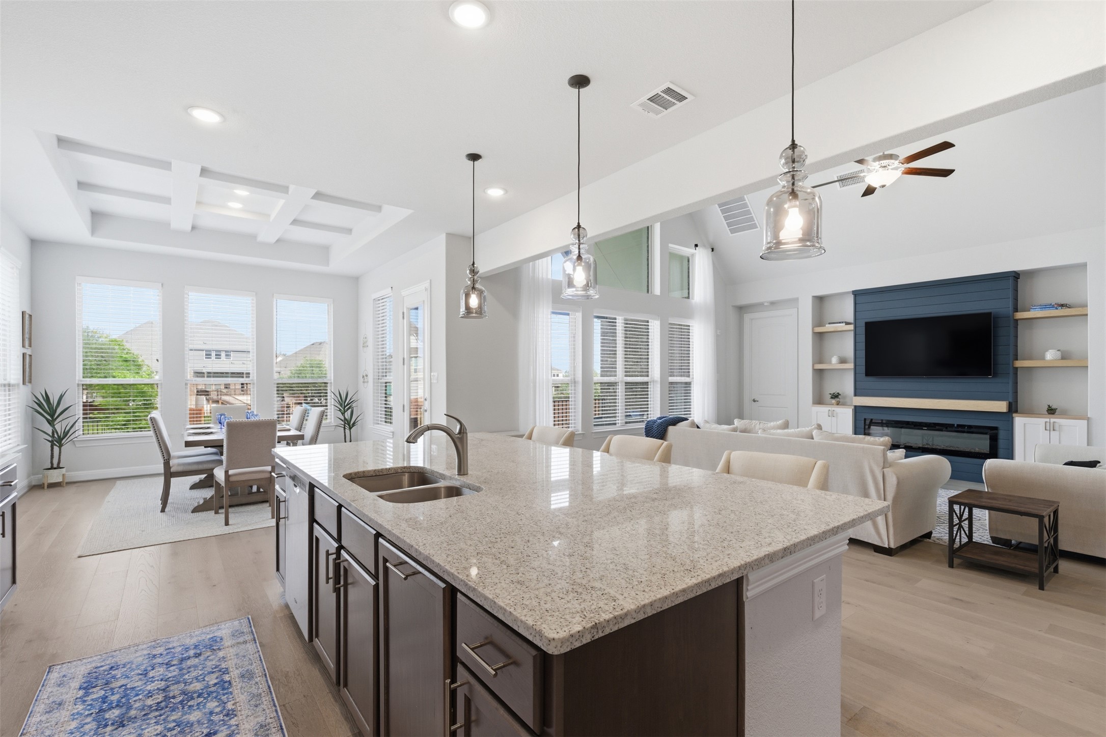 118 Bear Paw Run Georgetown, TX 78628 - Photo 11 of 35 This open concept living space features a kitchen island with a granite countertop and dual sinks, hardwood floors, recessed lighting, and a coffered ceiling