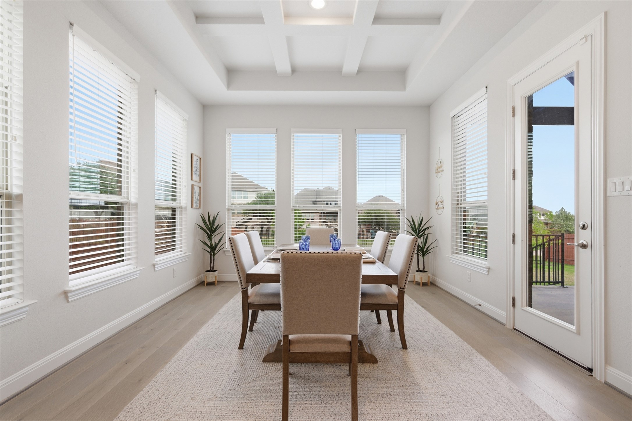 118 Bear Paw Run Georgetown, TX 78628 - Photo 13 of 35 This bright dining area features an elegant coffered ceiling, light wood-look flooring, and a glass-paneled door leading to an outdoor space