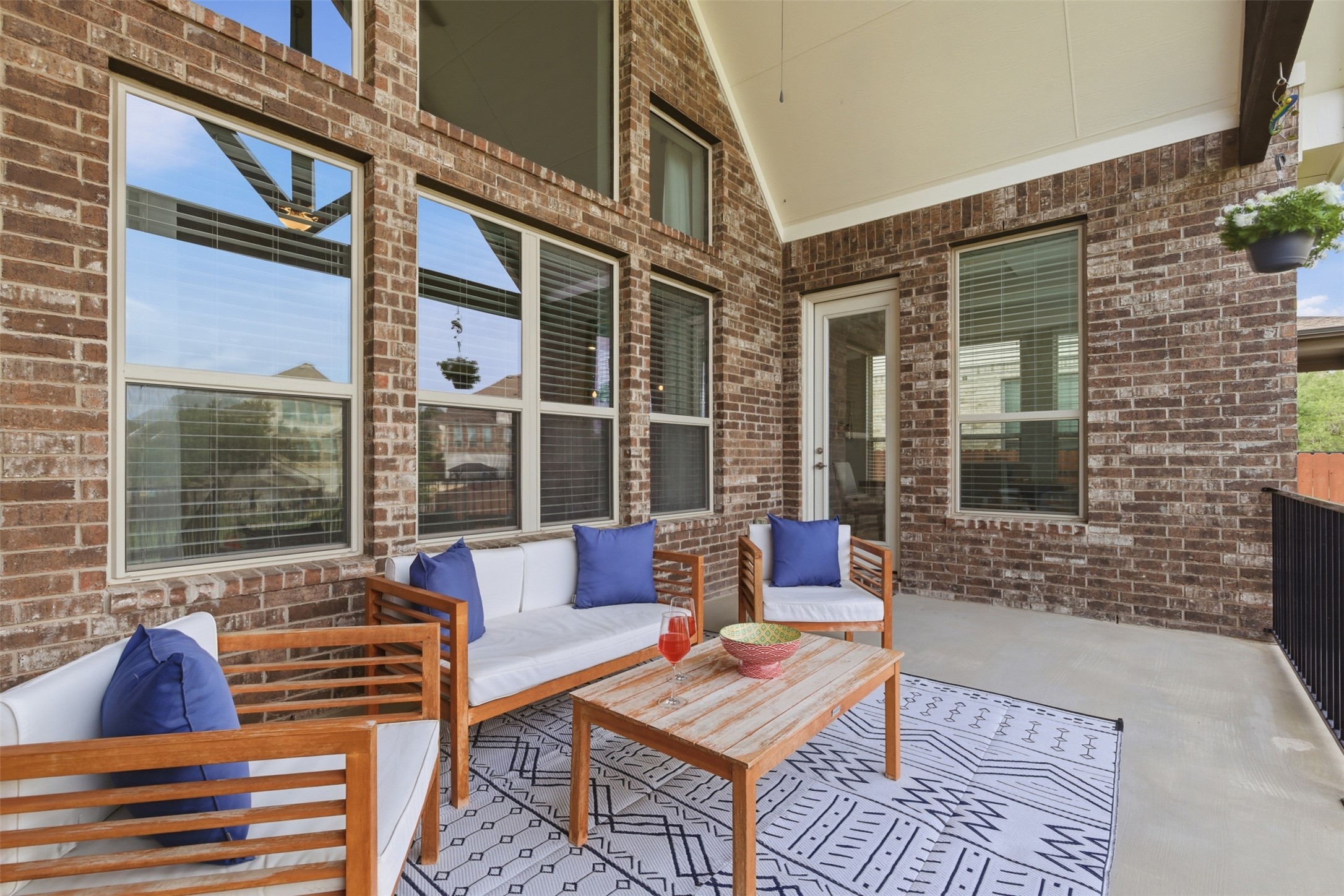 118 Bear Paw Run Georgetown, TX 78628 - Photo 24 of 35 This covered patio features a brick exterior wall with large windows, a vaulted ceiling, and a concrete floor