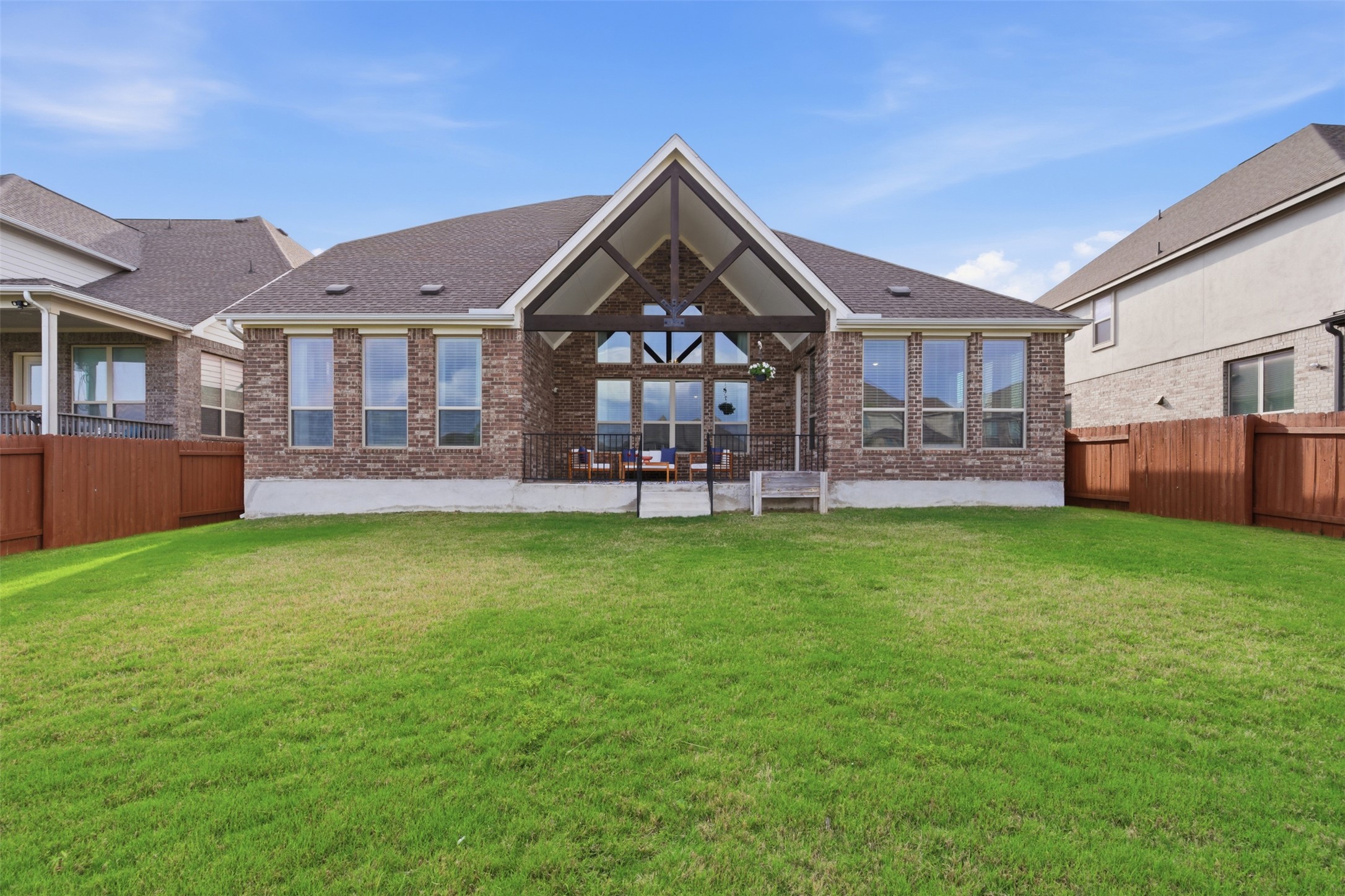 118 Bear Paw Run Georgetown, TX 78628 - Photo 26 of 35 The property features a brick exterior, a covered patio with an exposed beam ceiling, and a spacious lawn