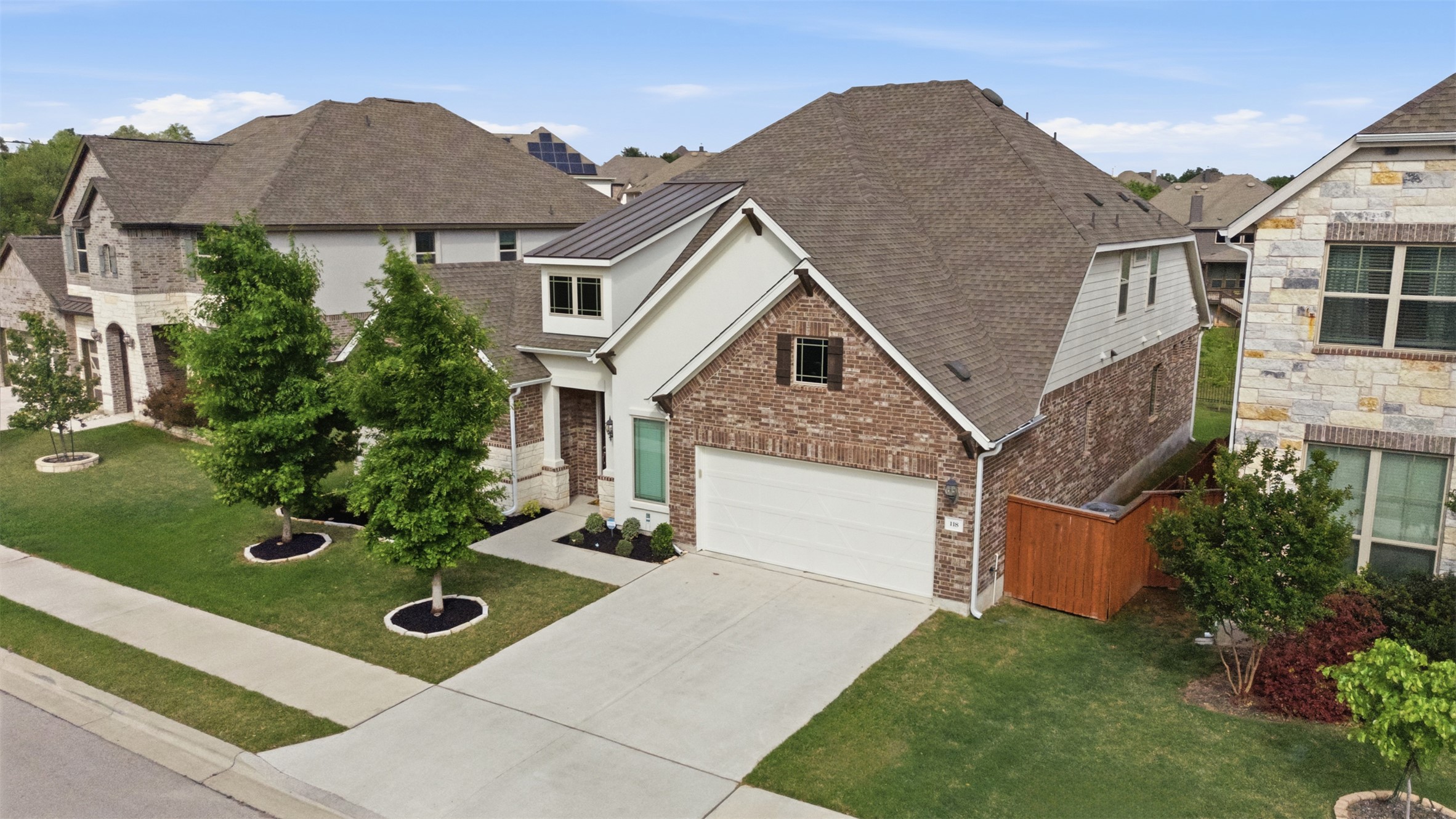 118 Bear Paw Run Georgetown, TX 78628 - Photo 29 of 35 The property features a combination of brick and siding on its exterior, a prominent garage, and a well-maintained lawn with trees