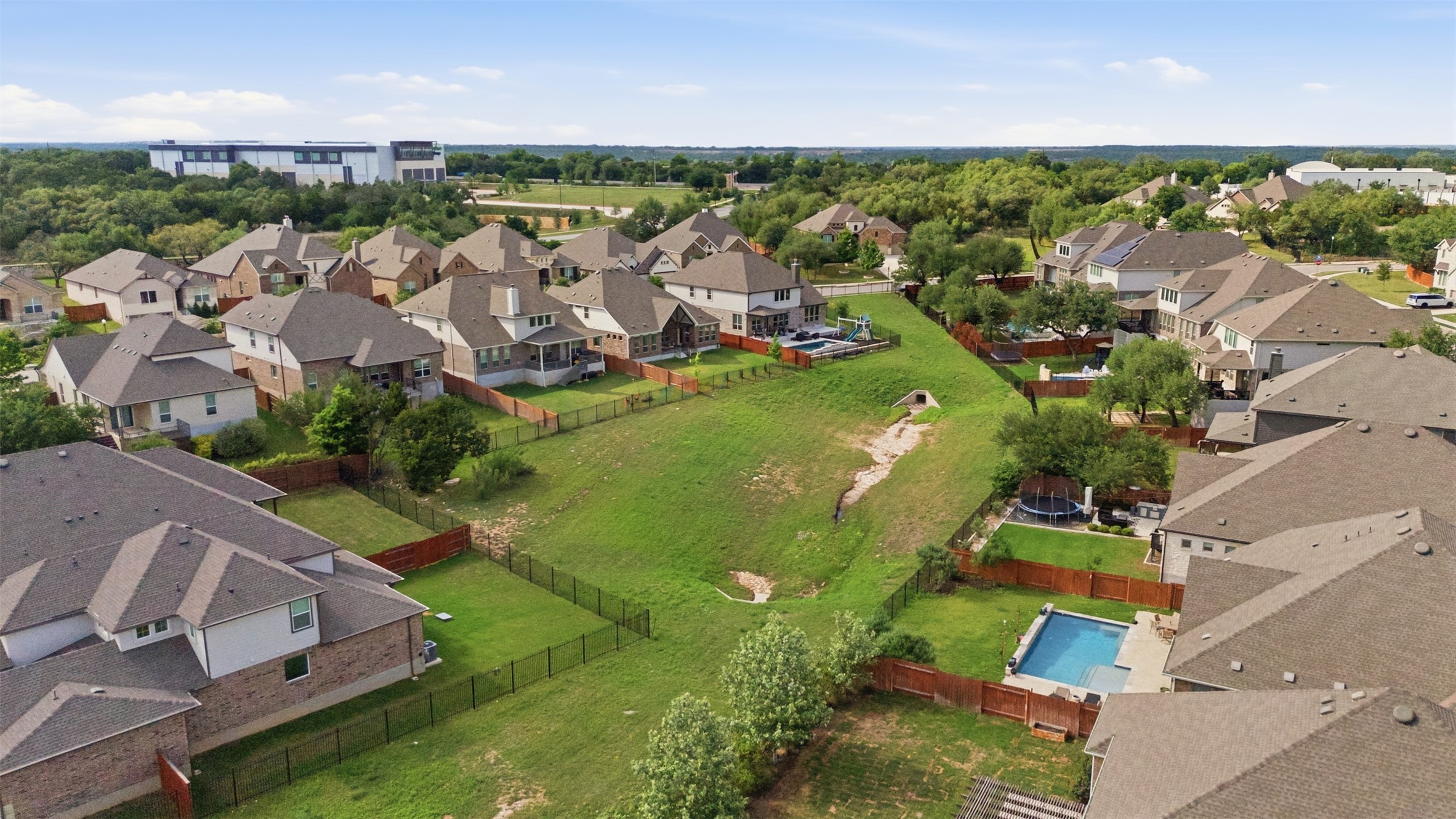 118 Bear Paw Run Georgetown, TX 78628 - Photo 30 of 35 Aerial view showcasing a residential neighborhood with several properties featuring private yards, some with swimming pools, and a substantial green space