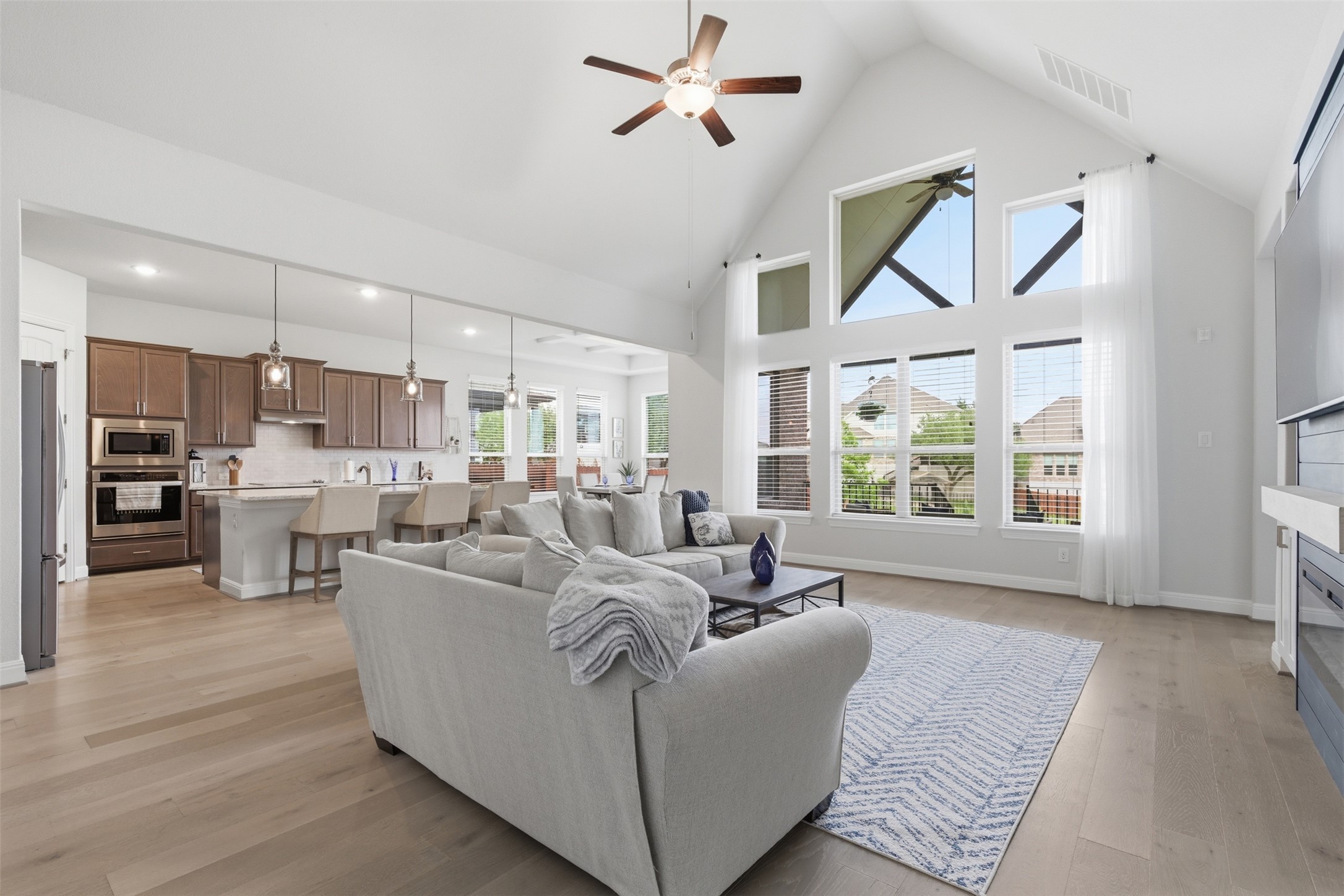 118 Bear Paw Run Georgetown, TX 78628 - Photo 5 of 35 The great room features high vaulted ceilings with a ceiling fan, light wood floors, and large windows providing natural light