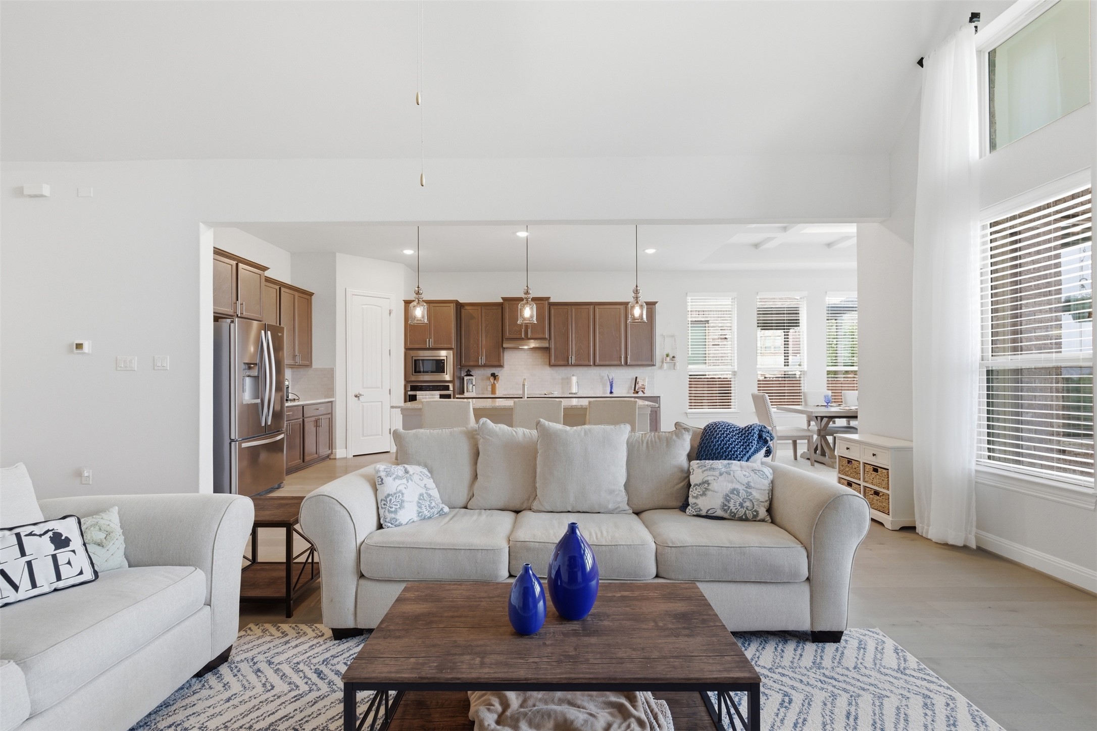 118 Bear Paw Run Georgetown, TX 78628 - Photo 7 of 35 The spacious living area features high ceilings, light-colored flooring, and large windows with blinds and sheer curtains