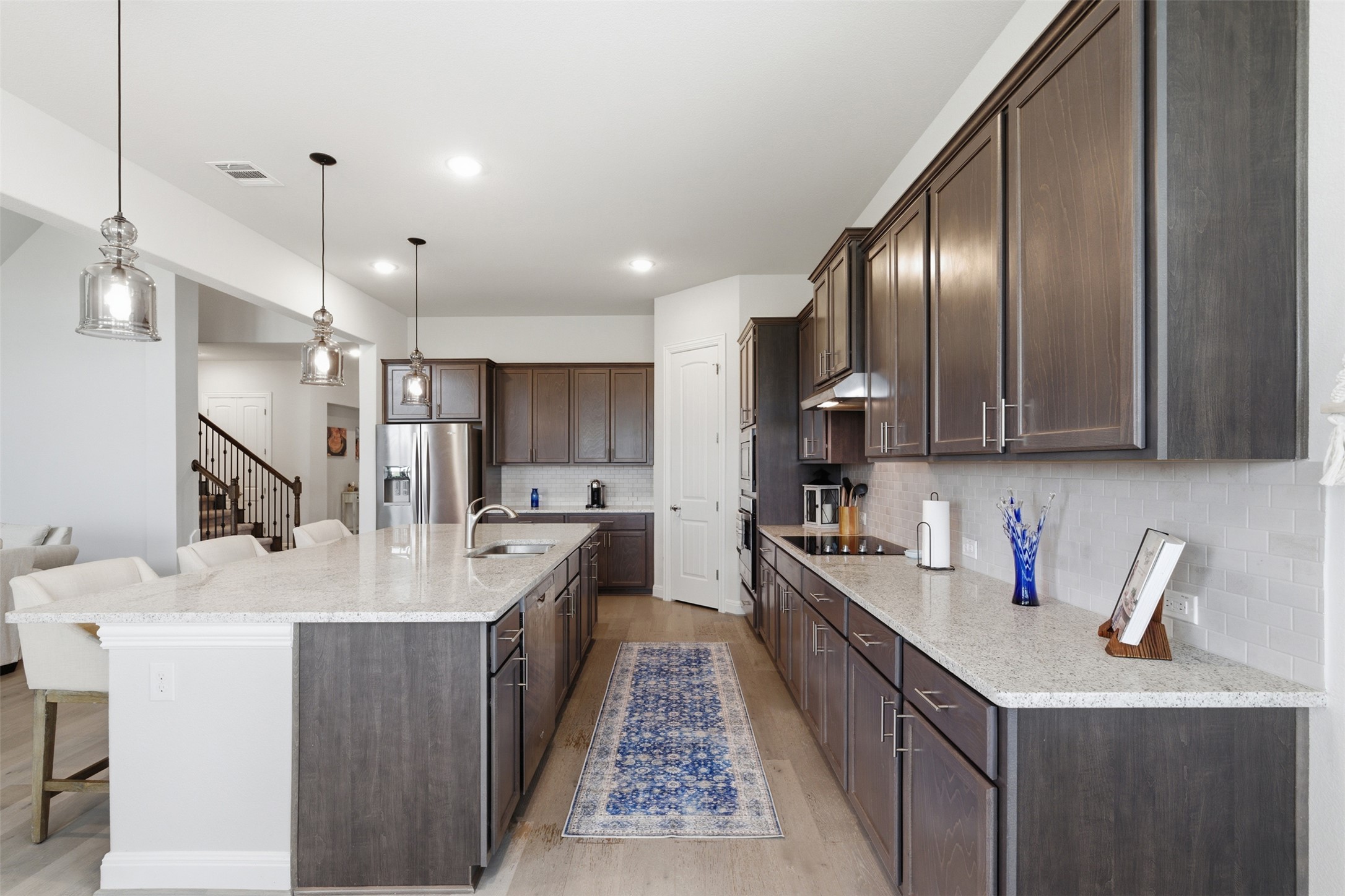 118 Bear Paw Run Georgetown, TX 78628 - Photo 10 of 35 The kitchen features an island with seating, dark wood cabinetry, light countertops, and stainless steel appliances
