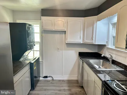 a kitchen with granite countertop stainless steel appliances a sink stove and refrigerator