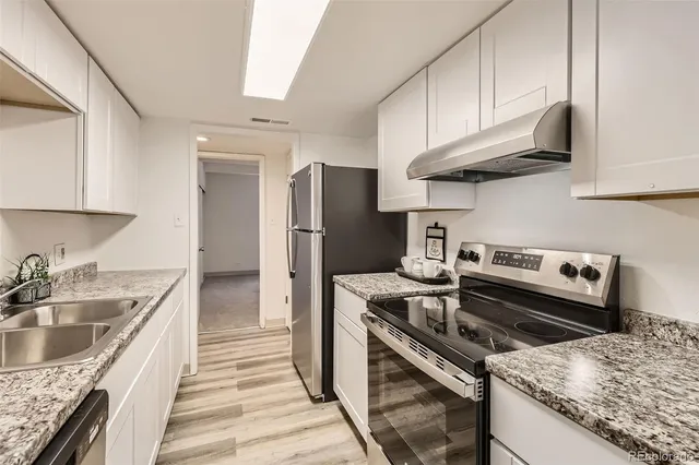 a kitchen with stainless steel appliances granite countertop a sink stove and refrigerator