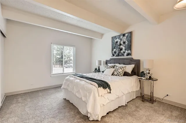 a large bed sitting in a bedroom next to a window