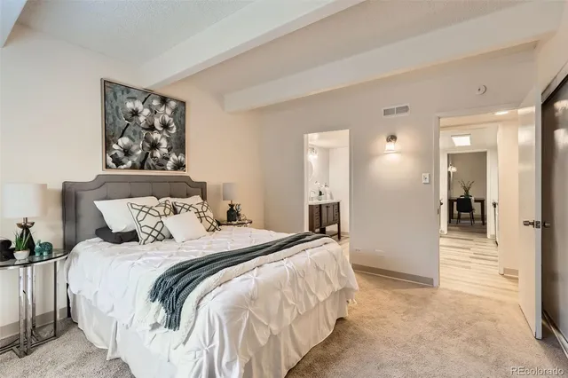 a spacious bedroom with a bed and a large mirror