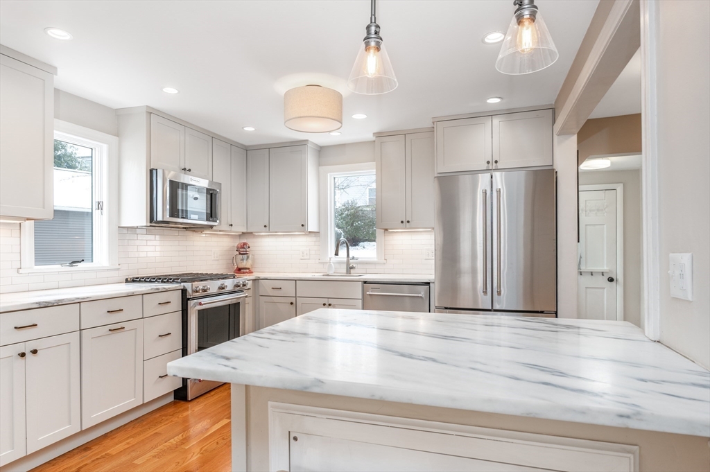 40 Waldorf Road Newton, MA 02461 - Photo 6 of 29 a kitchen with stainless steel appliances granite countertop a refrigerator a sink dishwasher a stove and white cabinets with wooden floor