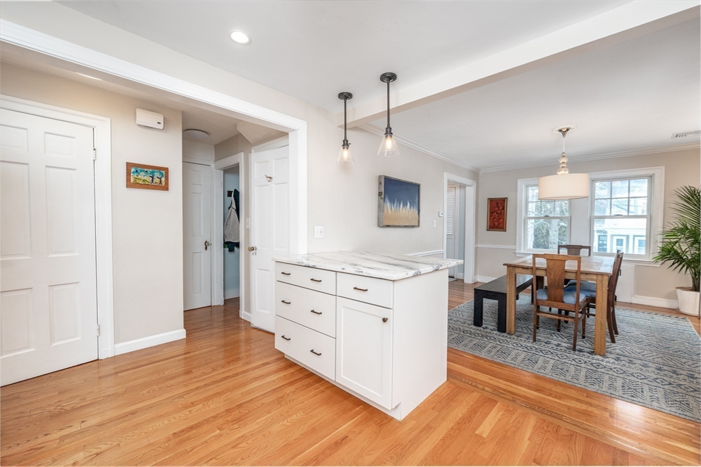 40 Waldorf Road Newton, MA 02461 - Photo 7 of 29 a kitchen with stainless steel appliances kitchen island granite countertop a stove a refrigerator and a dining table with wooden floor