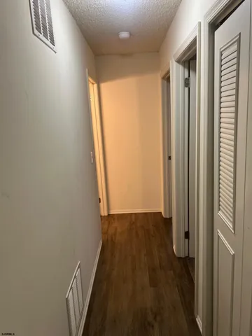 a view of a hallway with wooden floor and a window