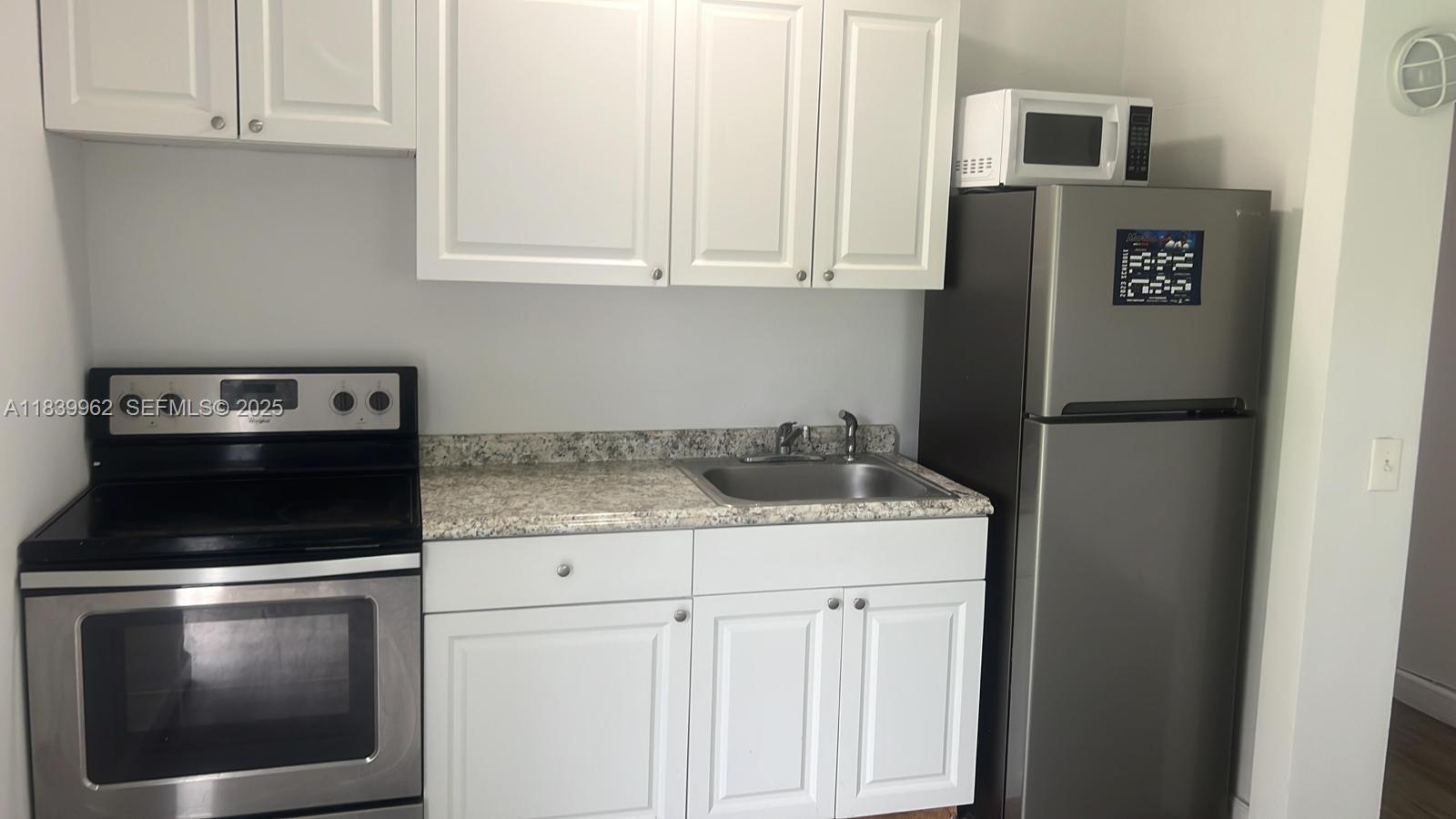 7230 Northwest 3rd Street Miami, FL 33126 - Photo 17 of 28 a kitchen with a stove microwave and refrigerator