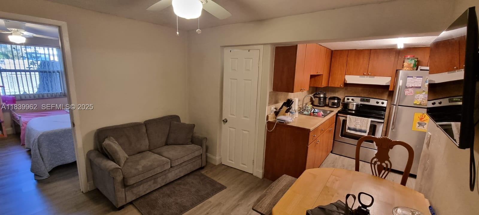 7230 Northwest 3rd Street Miami, FL 33126 - Photo 3 of 28 a living room with furniture a flat screen tv and kitchen view