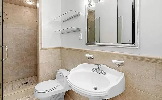 a bathroom with a sink a toilet and shower
