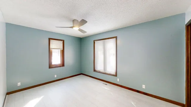 a view of a room with a ceiling fan and a window
