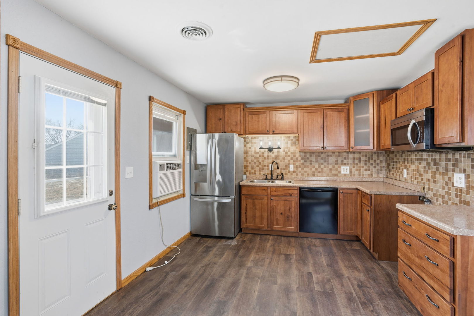 2515 West 69th Street Davenport, IA 52806 - Photo 6 of 15 a kitchen with stainless steel appliances granite countertop a refrigerator a sink dishwasher a stove with wooden cabinets and floors