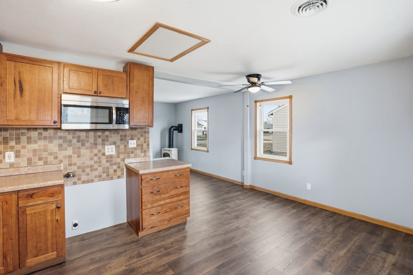 2515 West 69th Street Davenport, IA 52806 - Photo 7 of 15 a kitchen with granite countertop a stove top oven a sink dishwasher and a microwave oven on the wooden floor