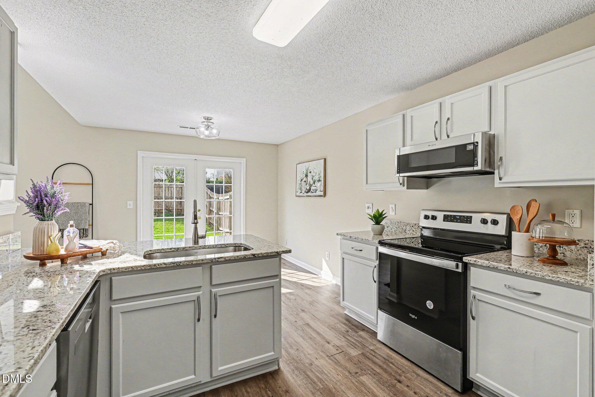 9904 Treymore Drive Raleigh, NC 27617 - Photo 9 of 33 a kitchen with granite countertop a sink stove and cabinets