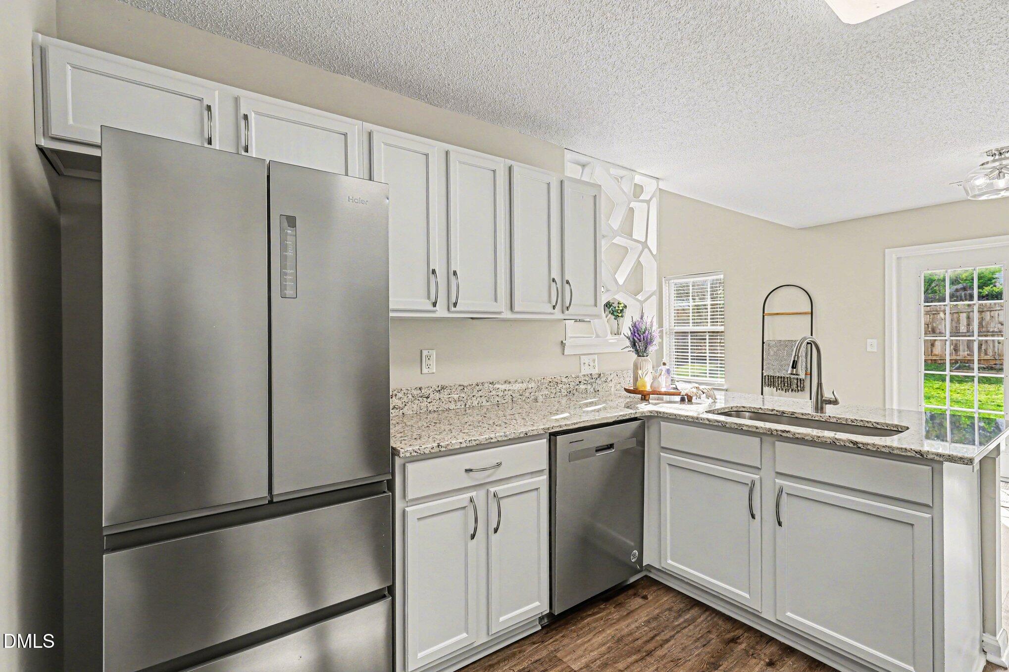 9904 Treymore Drive Raleigh, NC 27617 - Photo 11 of 33 a kitchen with a refrigerator sink and cabinets