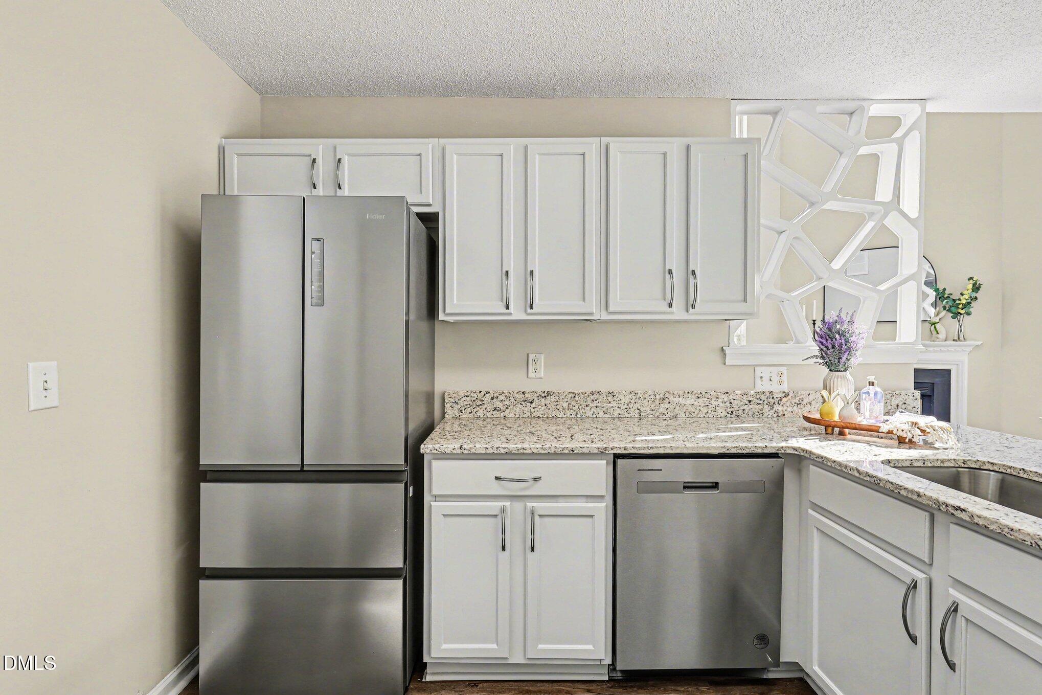 9904 Treymore Drive Raleigh, NC 27617 - Photo 12 of 33 a kitchen with stainless steel appliances white cabinets and a refrigerator