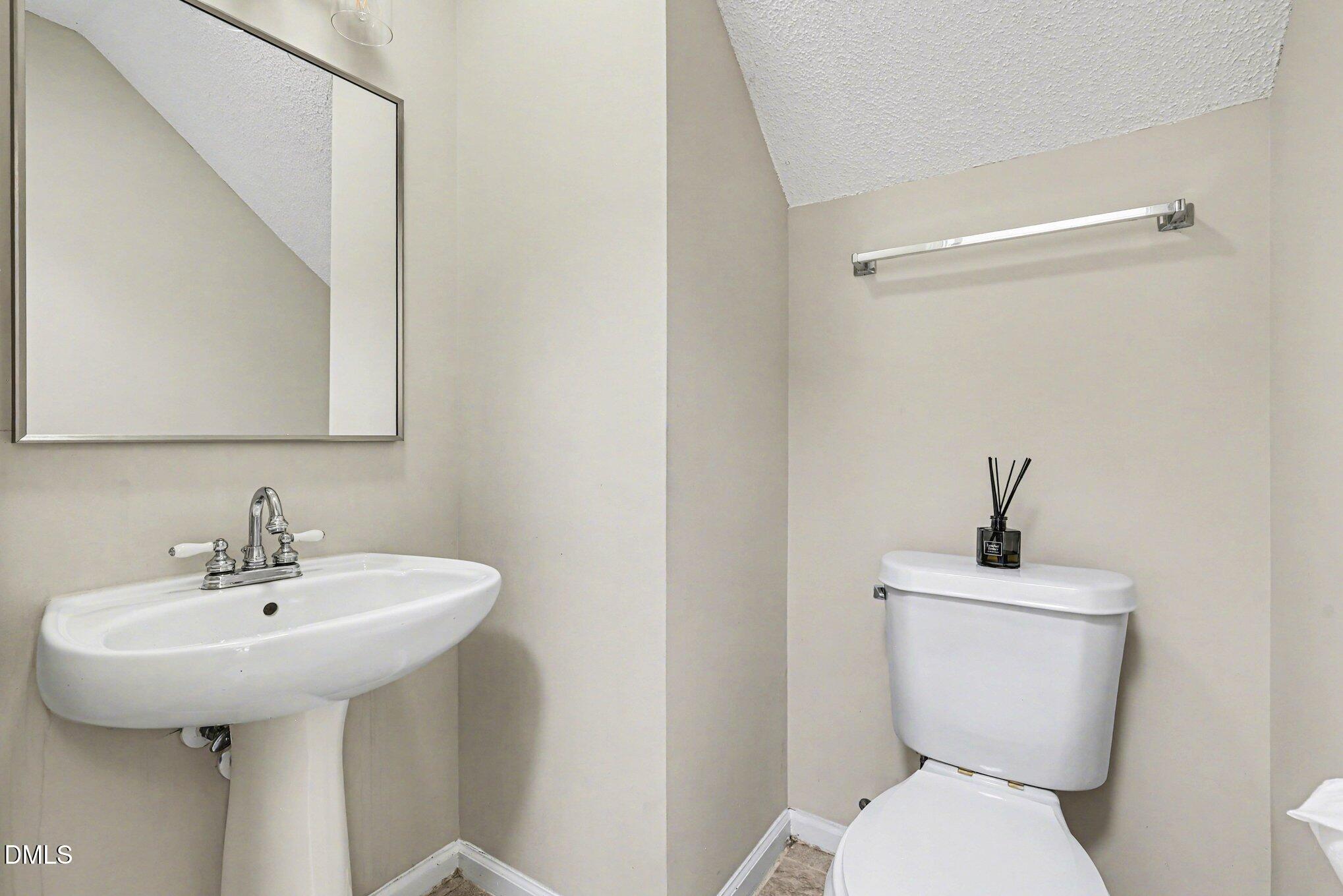9904 Treymore Drive Raleigh, NC 27617 - Photo 13 of 33 a bathroom with a toilet sink and mirror