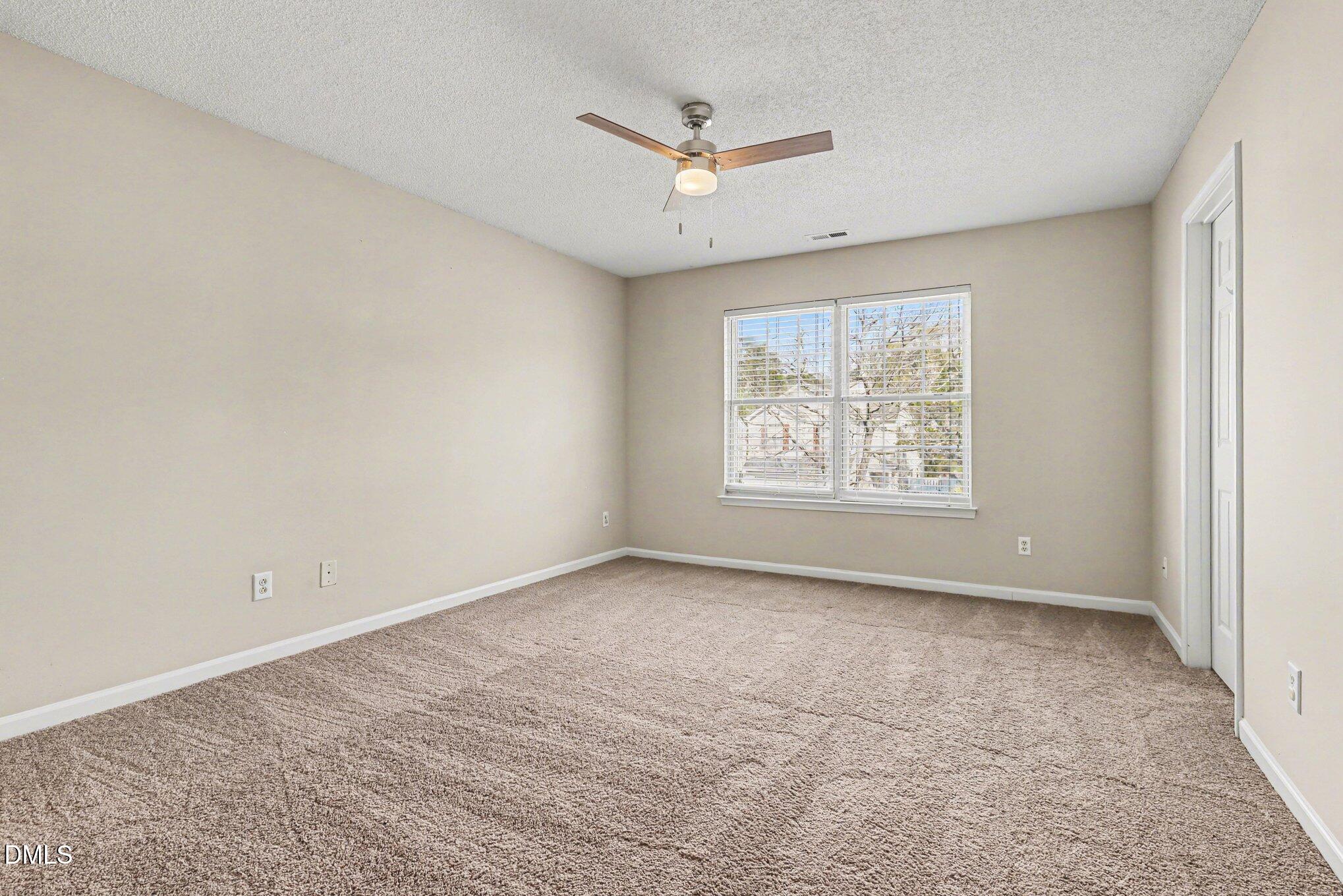 9904 Treymore Drive Raleigh, NC 27617 - Photo 14 of 33 an empty room with windows and ceiling fan