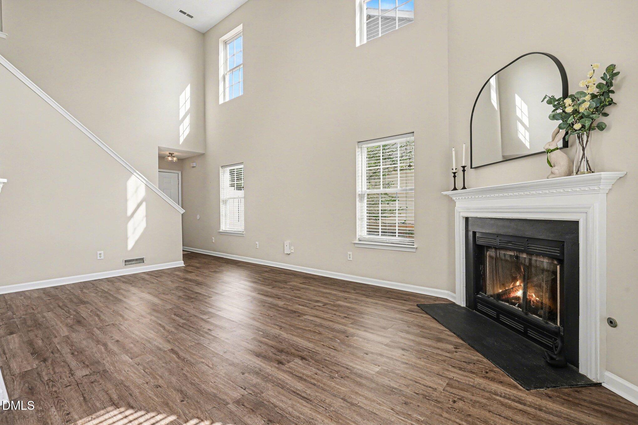 9904 Treymore Drive Raleigh, NC 27617 - Photo 6 of 33 a view of an empty room with wooden floor fireplace and a window
